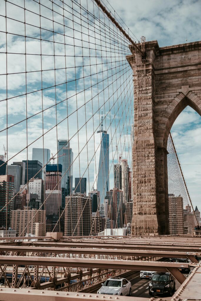 Iconic view of Brooklyn Bridge with Manhattan skyline and One World Trade Center in New York City.