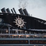 The Ultimate Guide to Your First MSC Cruise Passengers enjoy the evening view on the MSC cruise ship deck with smoke stacks.
