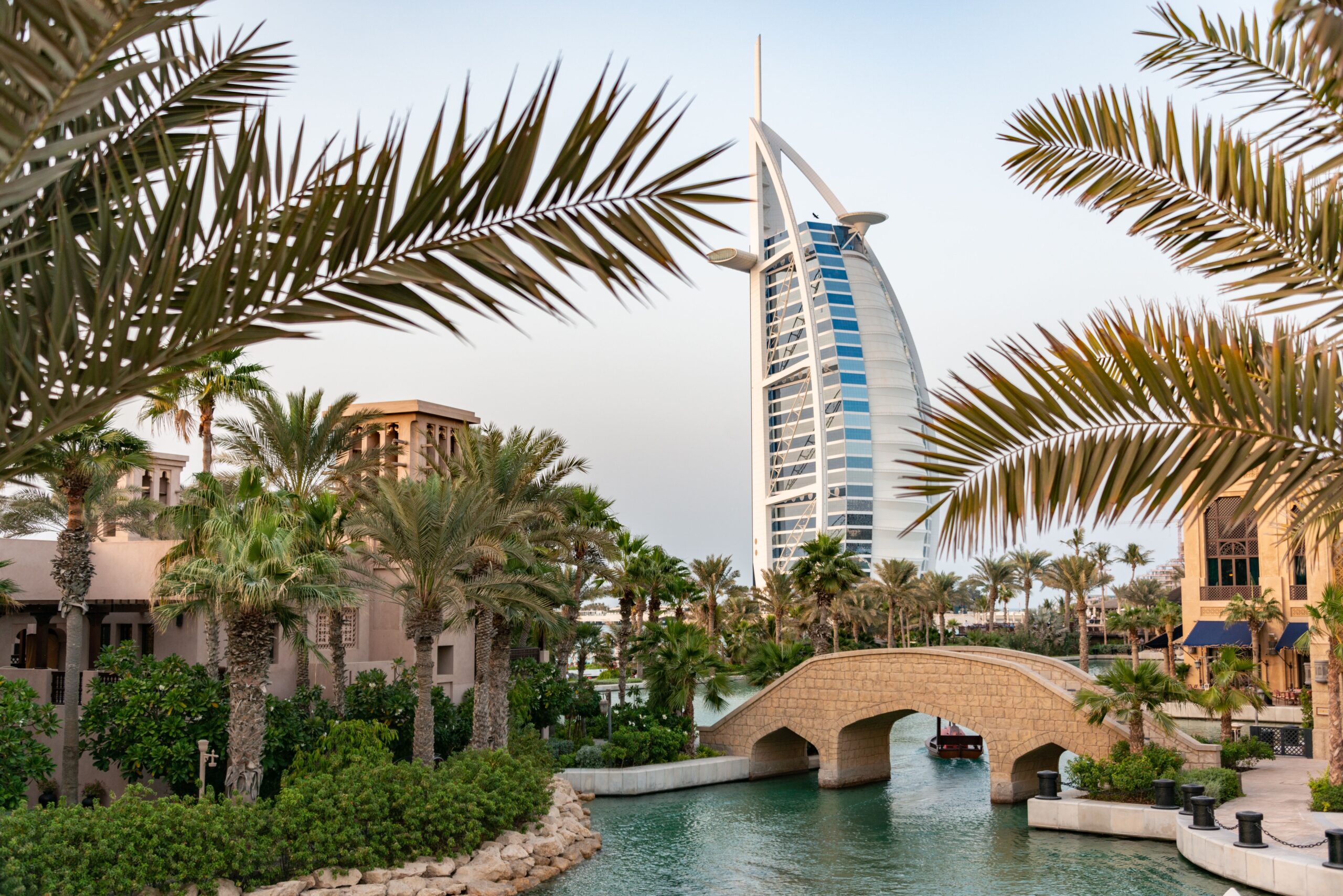 Travel Scenic view of Burj Al Arab with surrounding palm trees and bridge in Dubai, UAE.